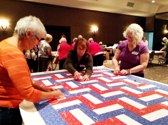 Volunteers tying a quilt