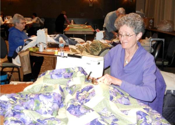 VQC member sewing quilt layers together
